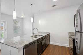 a renovated kitchen with granite counter tops and stainless steel appliances