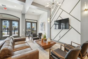 a living area with a couch and chairs and a television