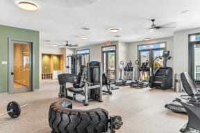 the gym has plenty of exercise equipment and windows