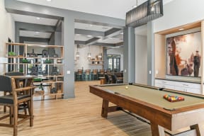 a community room with a pool table and a movie screen