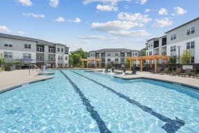 a swimming pool with an apartment building in the background