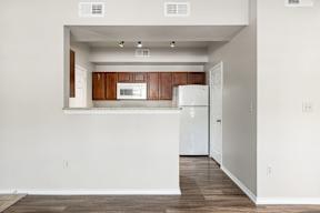 A kitchen with white appliances and wooden cabinets.
