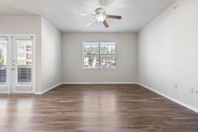 A room with a ceiling fan and a window with blinds.