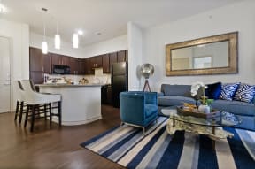 a living room and kitchen with a blue couch and a table