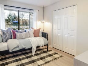 Second bedroom view with sliding door closets and day bed.