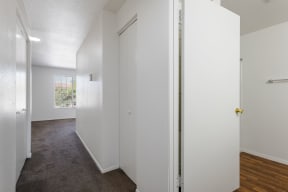 an empty room with white walls and a door to a closet