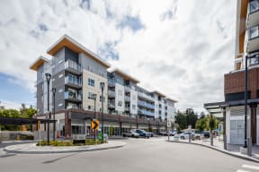 an apartment building on the corner of a street with cars