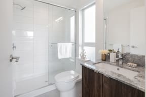 a white bathroom with a shower and a sink and a toilet