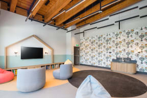 a living room with furniture and a wall with a house on it