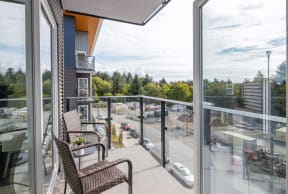 a balcony with two chairs and a view of a parking lot