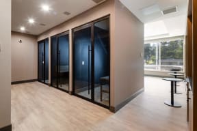 a corridor with glass doors and a table with stools