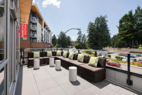 a large patio with couches and pillows on a balcony