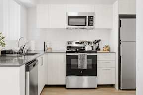 A modern kitchen with white cabinets and stainless steel appliances.