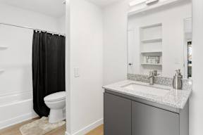A bathroom with a toilet, sink, and shower curtain.