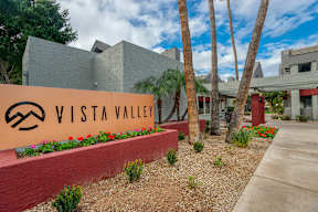 A sign that says Vista Valley in front of a building.