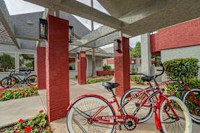 A red bicycle is parked under a covered walkway.
