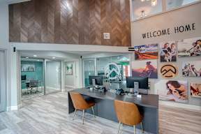 A modern office space with a wooden ceiling and a "Welcome Home" sign.