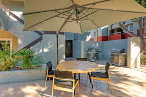 A patio with a table and chairs under an umbrella.