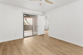 A room with a wooden floor and a ceiling fan.