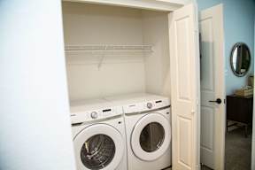Two washing machines in a small laundry room.