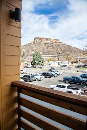 A parking lot with cars and a mountain in the background.