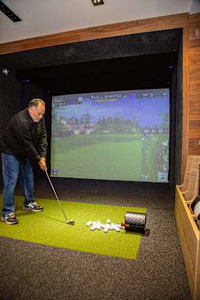 A man playing a golf game on a screen.