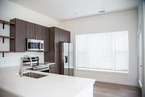 A modern kitchen with a white countertop and stainless steel appliances.