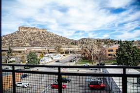 A view of a parking lot from a balcony with a mountain in the background.