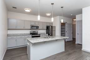 A modern kitchen with a granite countertop and stainless steel appliances.