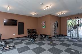 A spacious gym with a checkered floor and various exercise equipment.