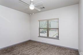 A room with a window and a ceiling fan.