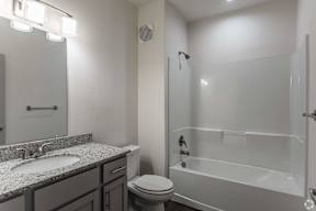 A white bathroom with a sink, toilet, and bathtub.