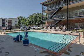 A swimming pool with a ladder and a building in the background.