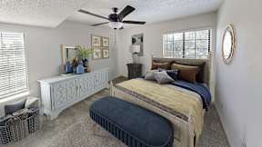 A bedroom with a bed, dresser, and ceiling fan.