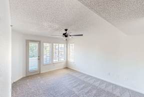 A room with a ceiling fan and a door leading outside.