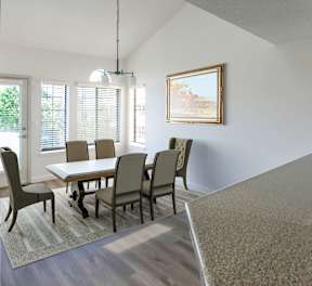 A dining room with a table and chairs.