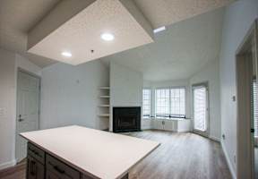 A large, empty room with a fireplace and a long table.