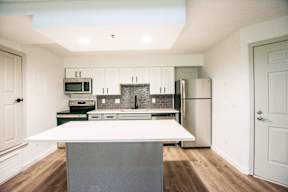 A kitchen with a white island in the middle of it.