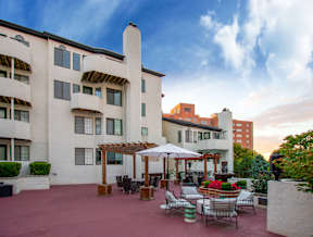A patio with a table and chairs is surrounded by a building.