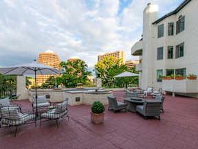 A patio with chairs and tables overlooking a city skyline.