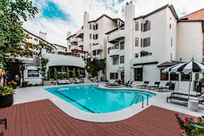 A large white building with a pool in front.