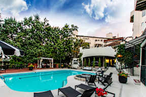 A pool with a black table and chairs in front of a building.