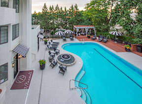 A pool with a table and chairs around it.