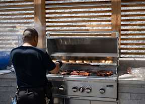 A man is cooking food on a grill.