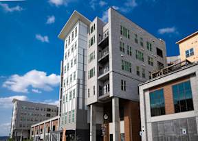 A modern multi-story building with a mix of white and grey exterior.