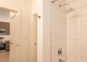 A white tiled shower area in a modern home.