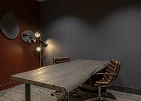 A brown leather chair sits in front of a wooden table.