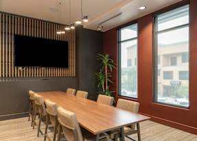 A conference room with a long table and chairs.