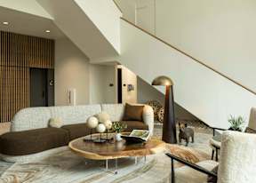 A modern living room with a brown couch and a wooden coffee table.