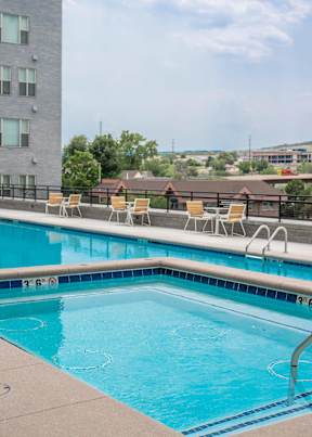 A swimming pool with a blue tiled edge and a white chair on the side.